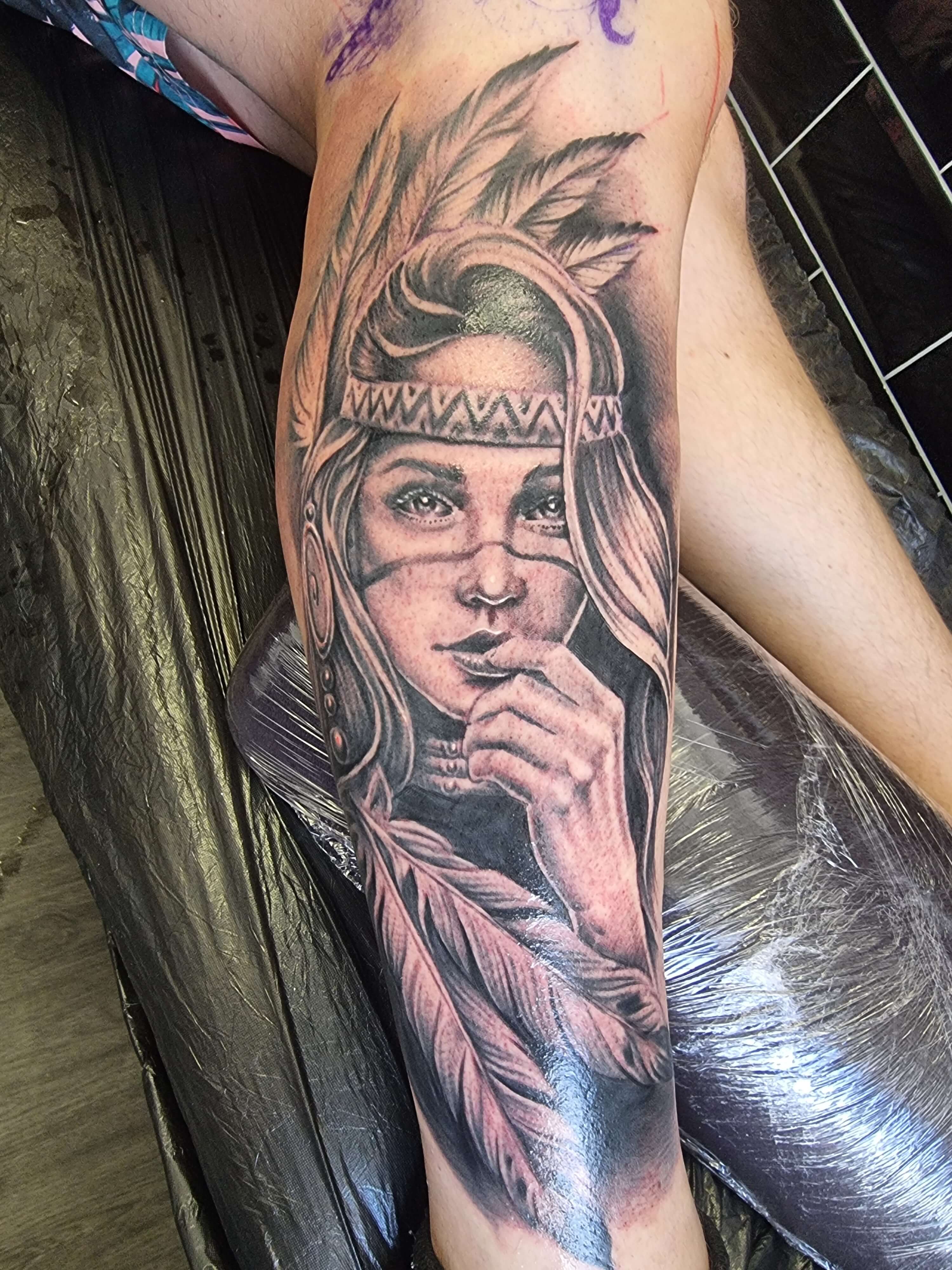 Black and grey realism tattoo of a detailed rose with water droplets on petals and leaves, created at Old Stone Tattoo House in Athlone, Ireland